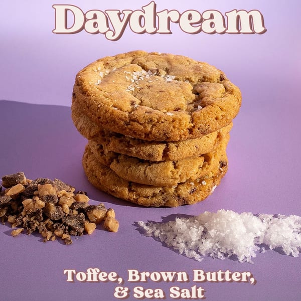 Stack of Daydream cookies with toffee bits and sea salt on a purple background.
